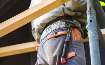 construction-worker-in-overalls-with-hammer-standi-P7R4BUD-400×250