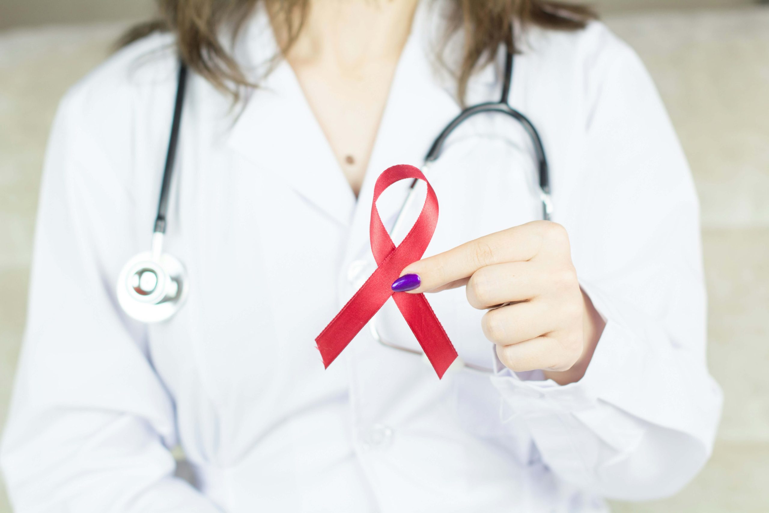 Doctor holding breast cancer badge